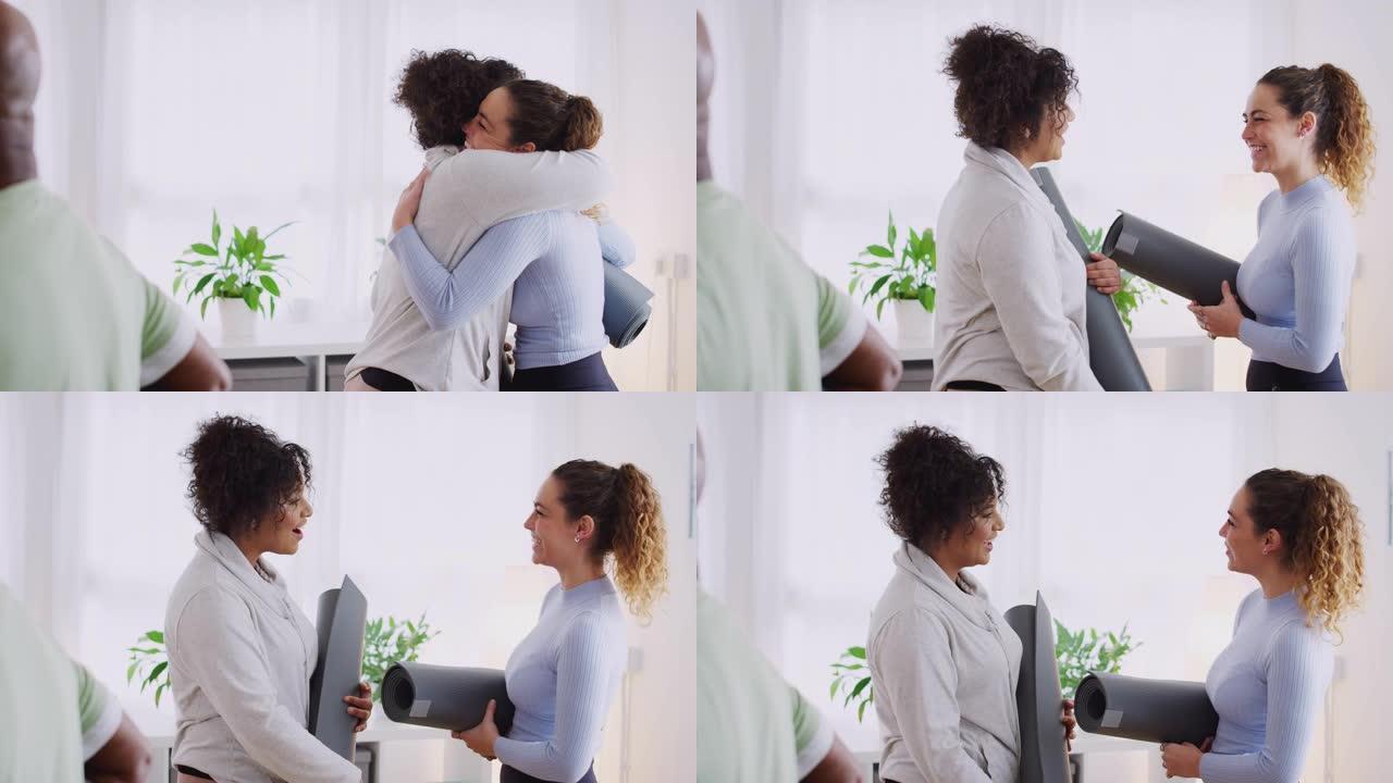 两个女性朋友在社区中心见面参加健身或瑜伽课时拥抱