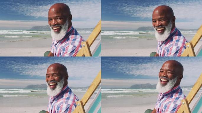 mixe种族高级男子坐在沙滩上微笑的肖像
