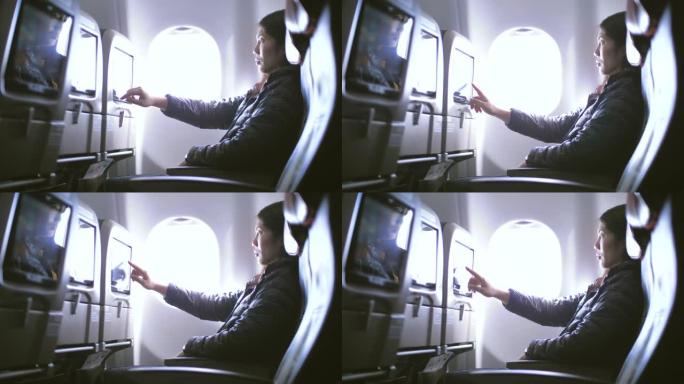 飞机内部有女性乘客，在飞机机舱上使用多媒体触摸屏，慢动作