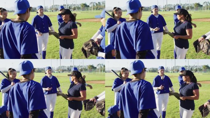 各种各样的女棒球运动员在场上用剪贴板聆听女教练