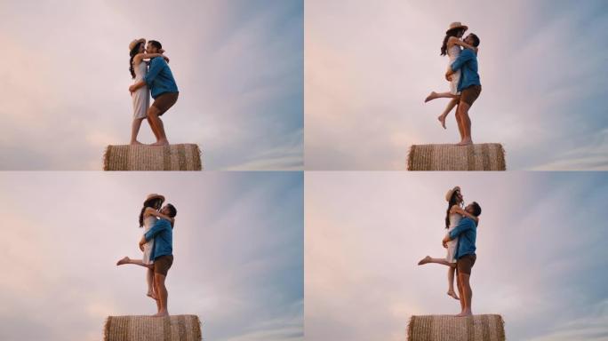 中年夫妇站在干草捆升降机上拥抱和亲吻的手持慢动作镜头