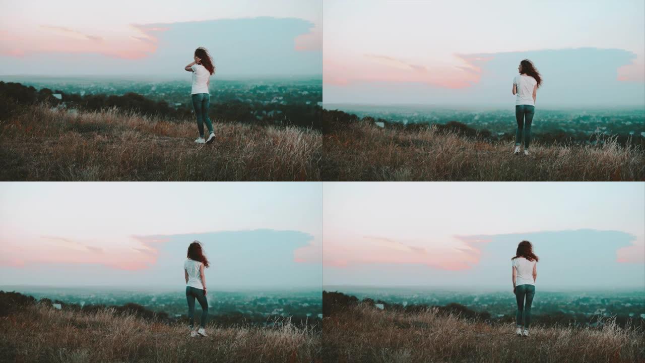 这位年轻女子站在乡村背景的山上