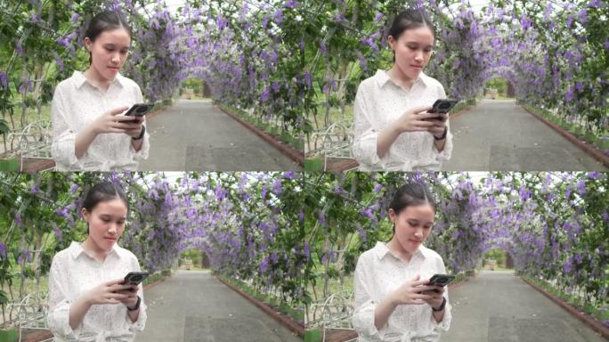 亚洲美丽的少女在公园使用智能手机