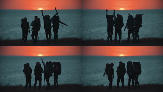 日落背景下步行到海边的四个旅行者