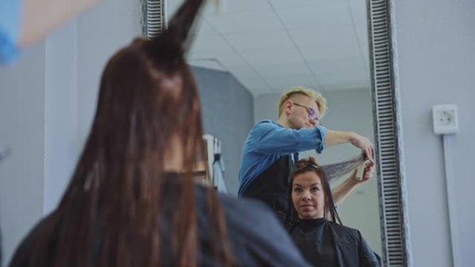 发型师在沙龙梳理和切割女性头发