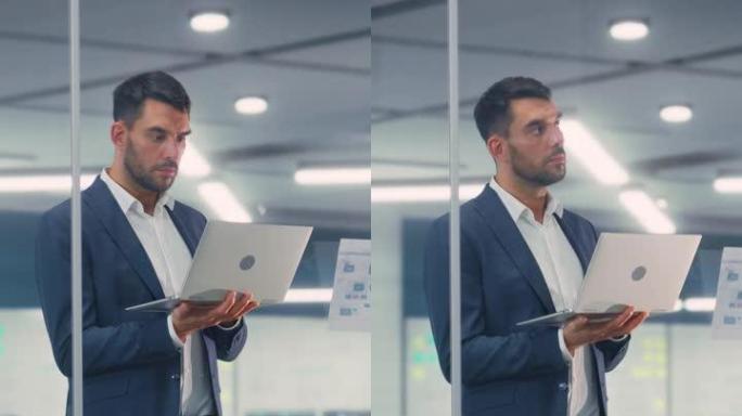 一个自信的商人在现代办公室使用笔记本电脑的垂直肖像。从事商业、金融和营销项目的时尚经理。销售专家浏览