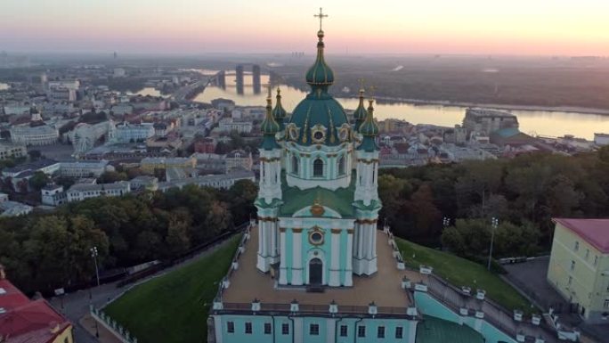 乌克兰基辅。日出时在东正教圣安德鲁教堂周围飞行。波迪尔河和第聂伯河的景色。空中射击，4K