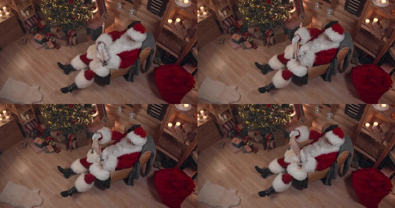 一个圣诞老人甜蜜地睡在扶手椅上，手里拿着长卷轴，我们看到他在一间装饰精美的房子里，圣诞树在灯光下