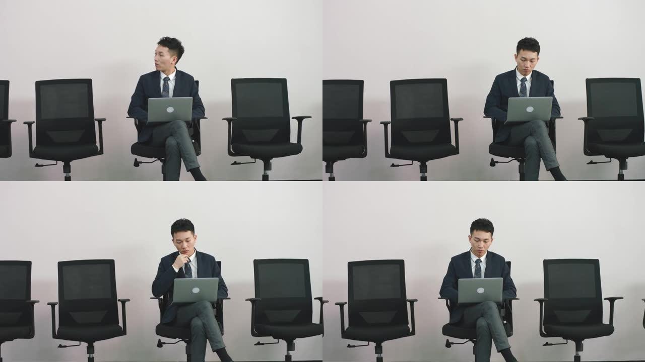 年轻的亚洲求职者坐在椅子上等待面试