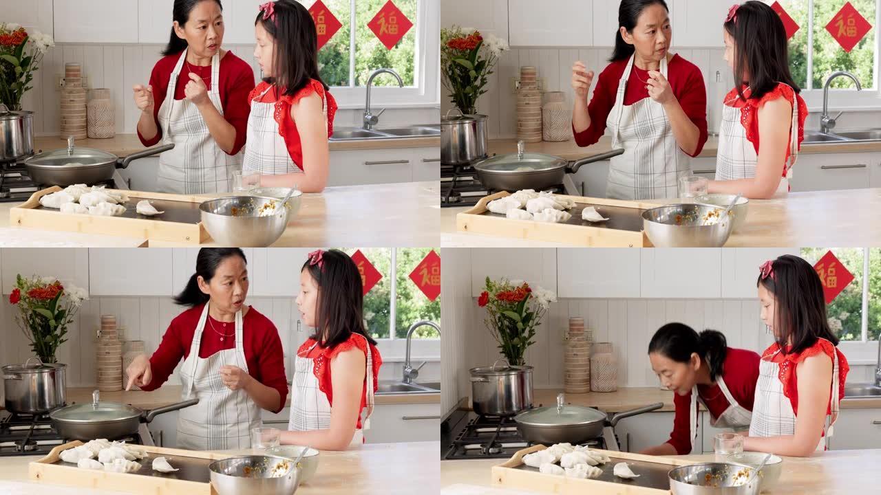 食物，母亲和女孩在厨房里煮饺子，中国菜和在家里的结合。儿童，学习和妈妈在中国的家中帮助女儿提供传统，
