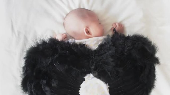 黑翅膀睡在床上的婴儿