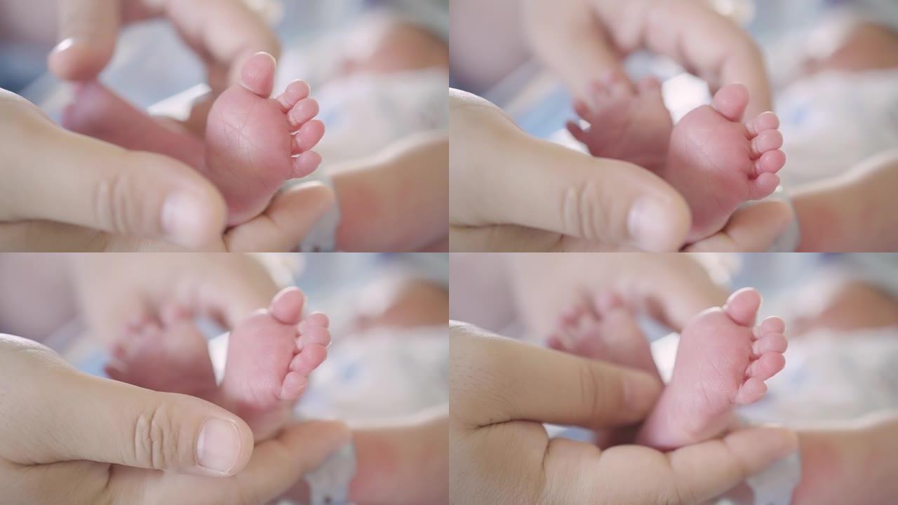母亲在医院分娩后用手抚摸婴儿的小脚