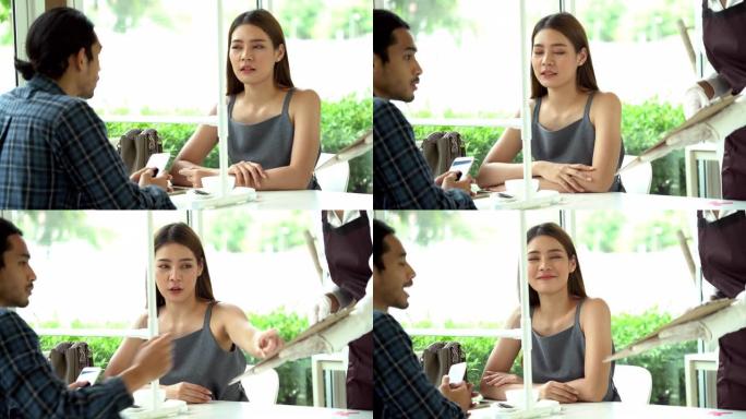 平移镜头: 亚洲夫妇在新常态和社交距离重新开放餐厅用餐