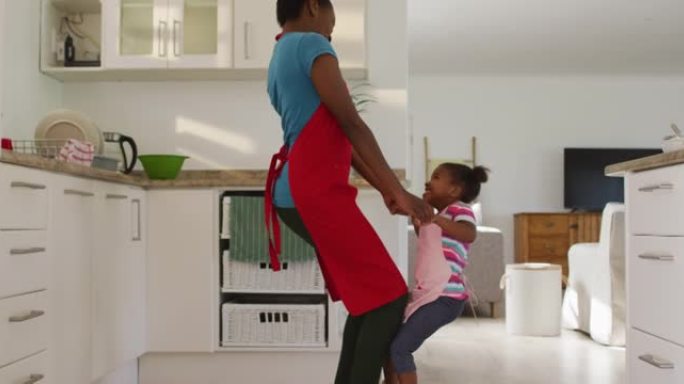 快乐的非洲裔美国母女在厨房跳舞和娱乐