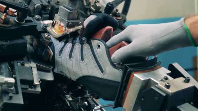 工业机器被用来塑造靴子。鞋类的工厂生产。