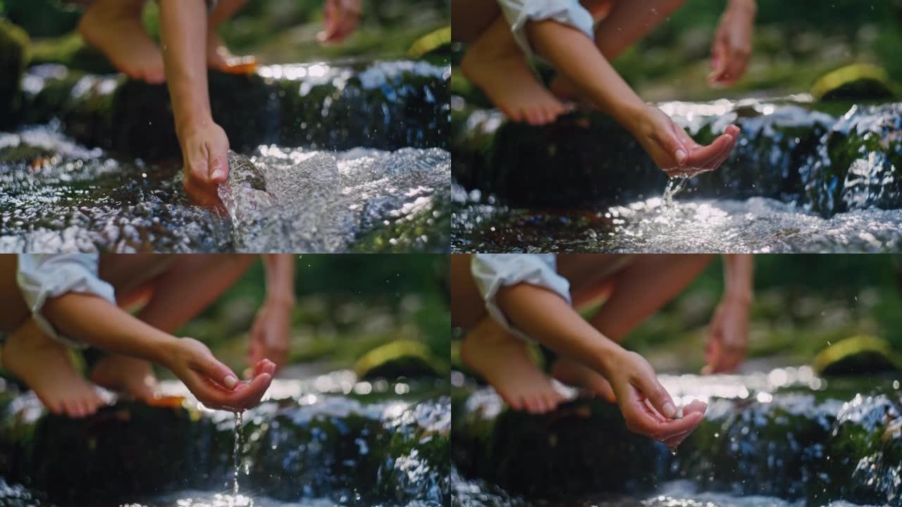 SLO MO年轻女子用手从溪流中舀出纯净水
