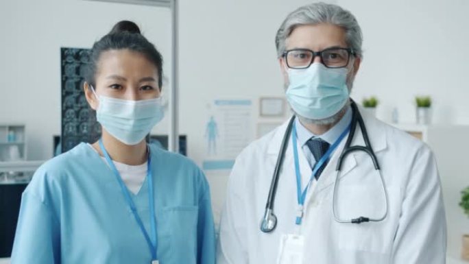 医生和护士戴着医用口罩和制服站在办公室的肖像