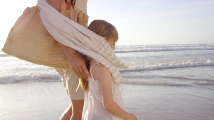 4k视频片段，一个小女孩在海滩上与父母结为纽带