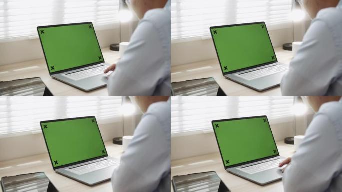 商人使用带有绿屏的笔记本电脑