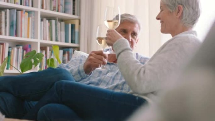 成熟的夫妇，在房子、家庭图书馆或客厅的沙发上喝酒和吐司庆祝。微笑，快乐或爱与高级男人和女人与酒精玻璃
