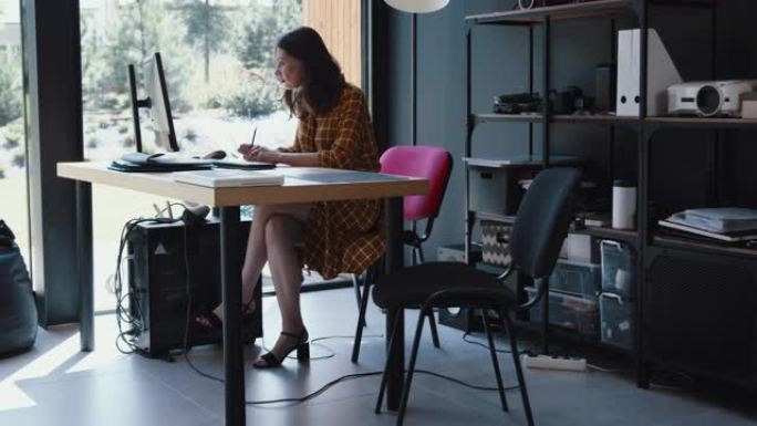 侧视图美丽严肃的黑发信息技术经理女商人独自在现代联合办公桌子慢动作工作。