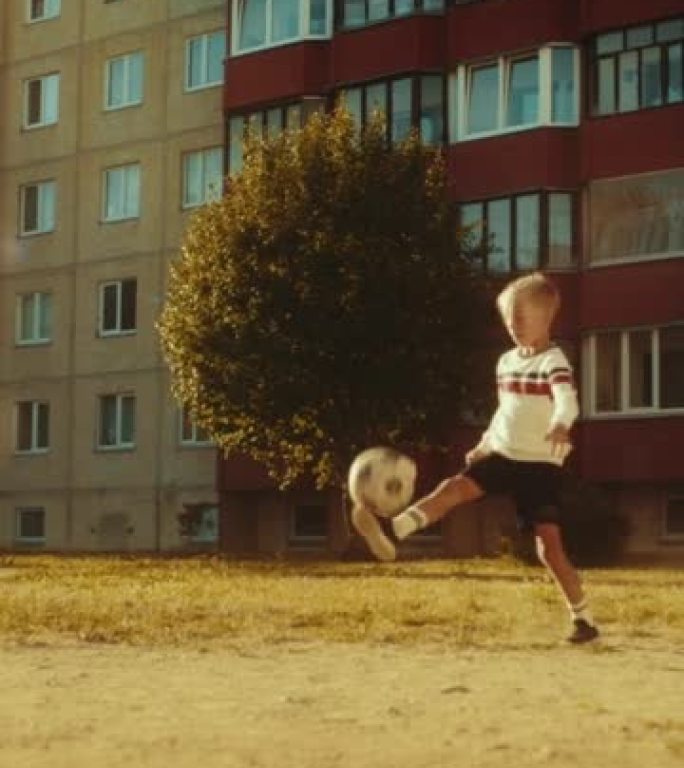 垂直射击: 年轻的高加索孩子在附近玩球。小男孩练习足球训练，踢足球。青少年梦想成为一名职业足球运动员