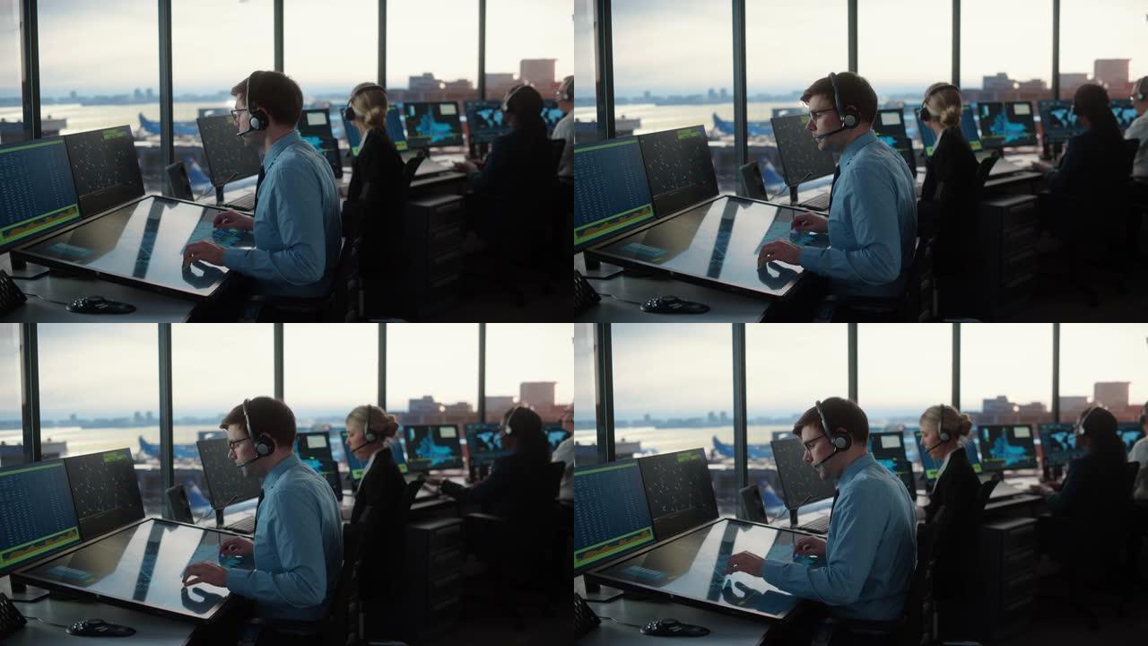 在机场塔台使用触摸屏面板的带耳机的男性空中交通管制员。办公室里到处都是带有导航屏幕，飞机出发和到达数