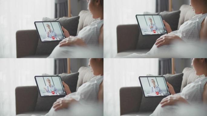 亚洲孕妇在家中与数字平板电脑上的医生进行视频通话