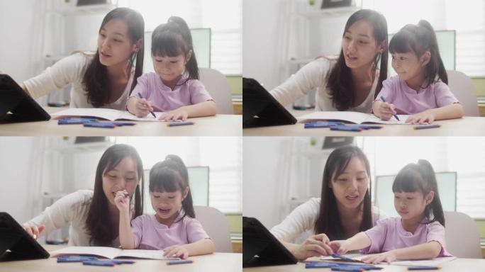 亚洲母女在家用数字平板电脑学习