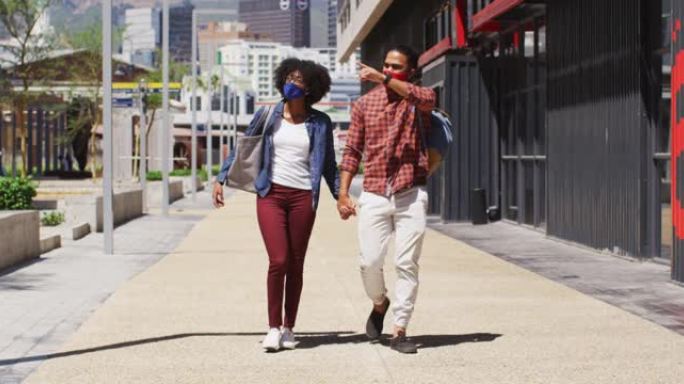 戴着口罩的多元化夫妇走路和牵手