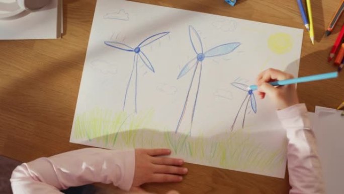 俯视图: 小女孩画漂亮的风力发电机，看起来像花。在阳光明媚的日子里，聪明的孩子将我们的星球想象成一个