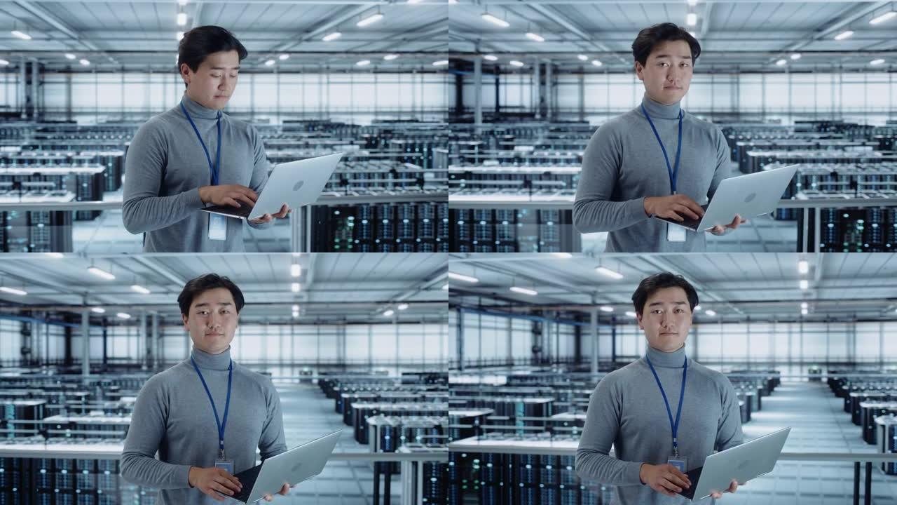 使用笔记本电脑的数据中心工程师的肖像。服务器机房专业设施，韩国男性系统管理员与数据保护网络合作，以实