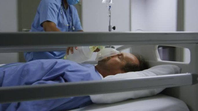 医院走廊口罩上戴着氧气面罩的病人的多元化医生群体