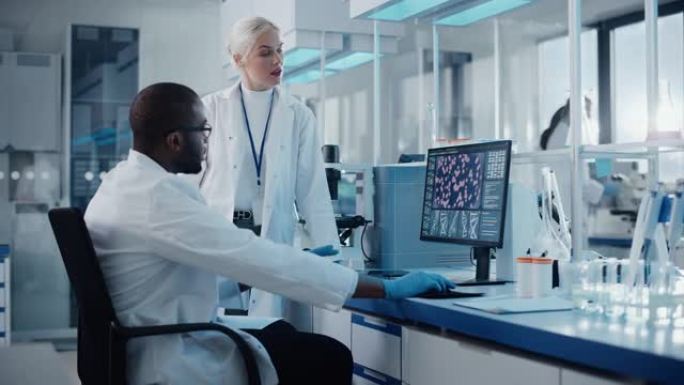 现代医学研究实验室: 两名科学家使用带有显示DNA基因分析屏幕的计算机，专家讨论创新技术。先进的医学