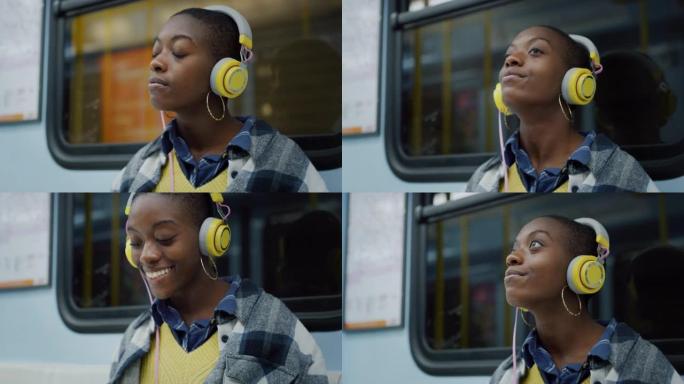 年轻黑人妇女在公共交通工具上戴上耳机，晚上微笑的肖像。非裔美国女少年在智能手机上使用音乐在线平台收听