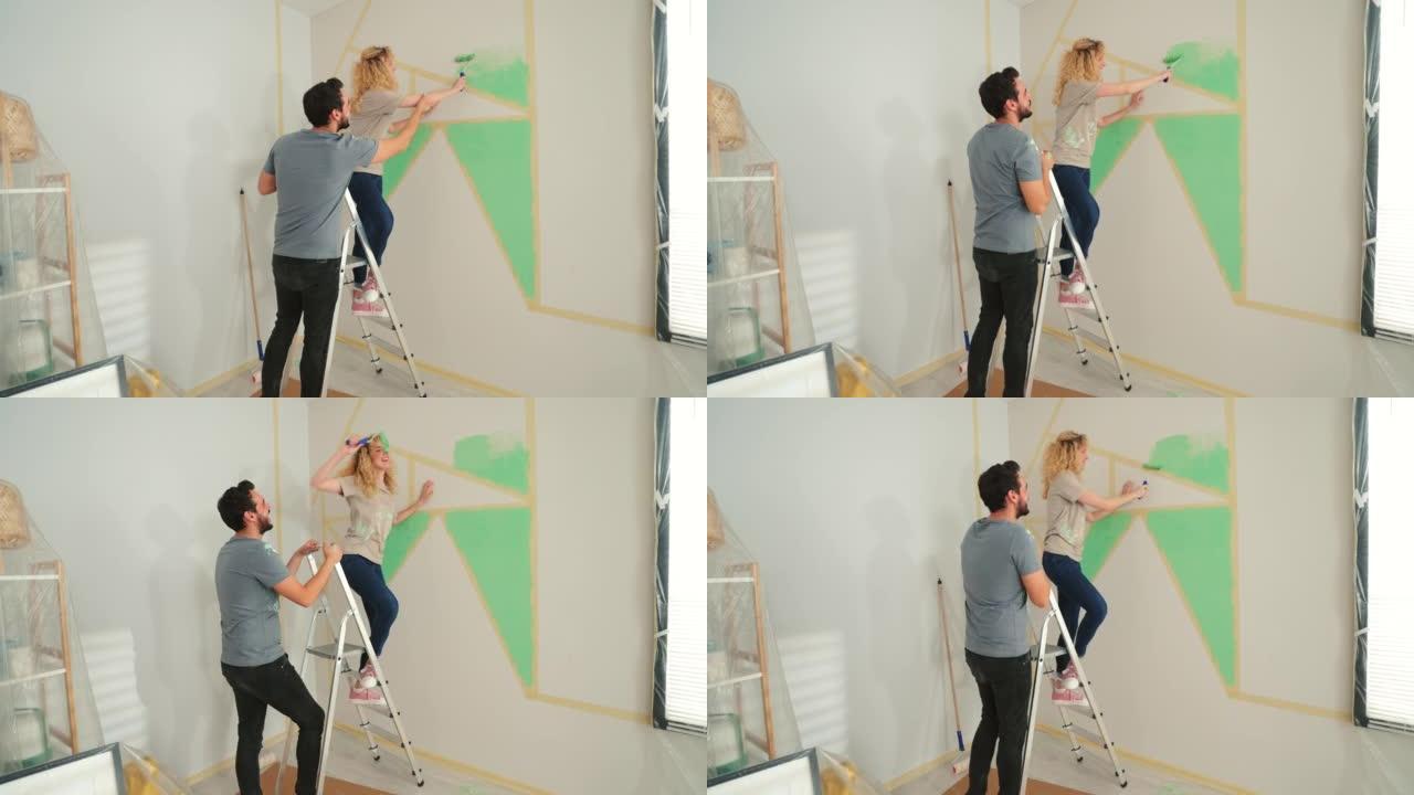 幸福的年轻夫妇在家粉刷墙壁。