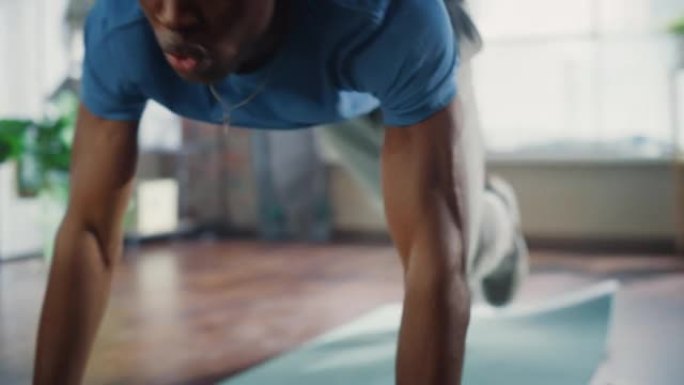 强壮集中的黑人在家里晨练时做有氧高膝盖和核心强化运动。健康的生活方式、健身和娱乐理念。移动摄像机拍摄
