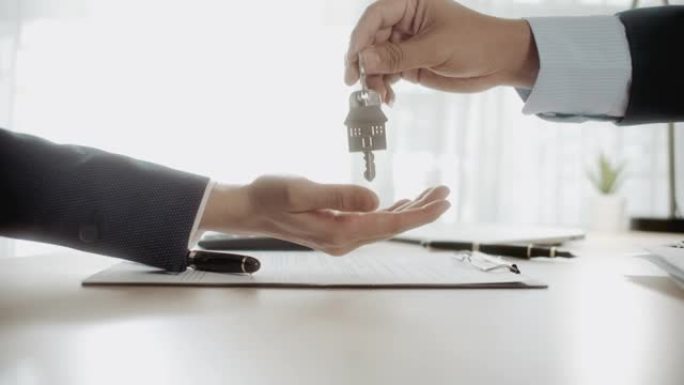 特写手给房子钥匙和握手，租赁和租赁概念