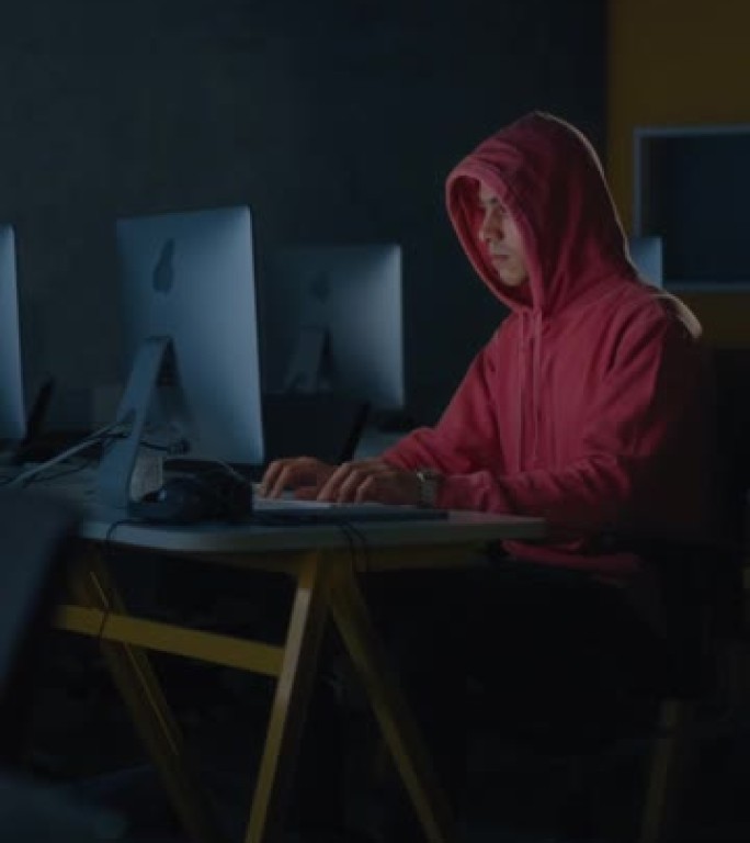 垂直屏幕: 男生独自坐在大学信息学室，晚上在计算机科学项目上工作。年轻的学者在大学学习计算机，在课堂