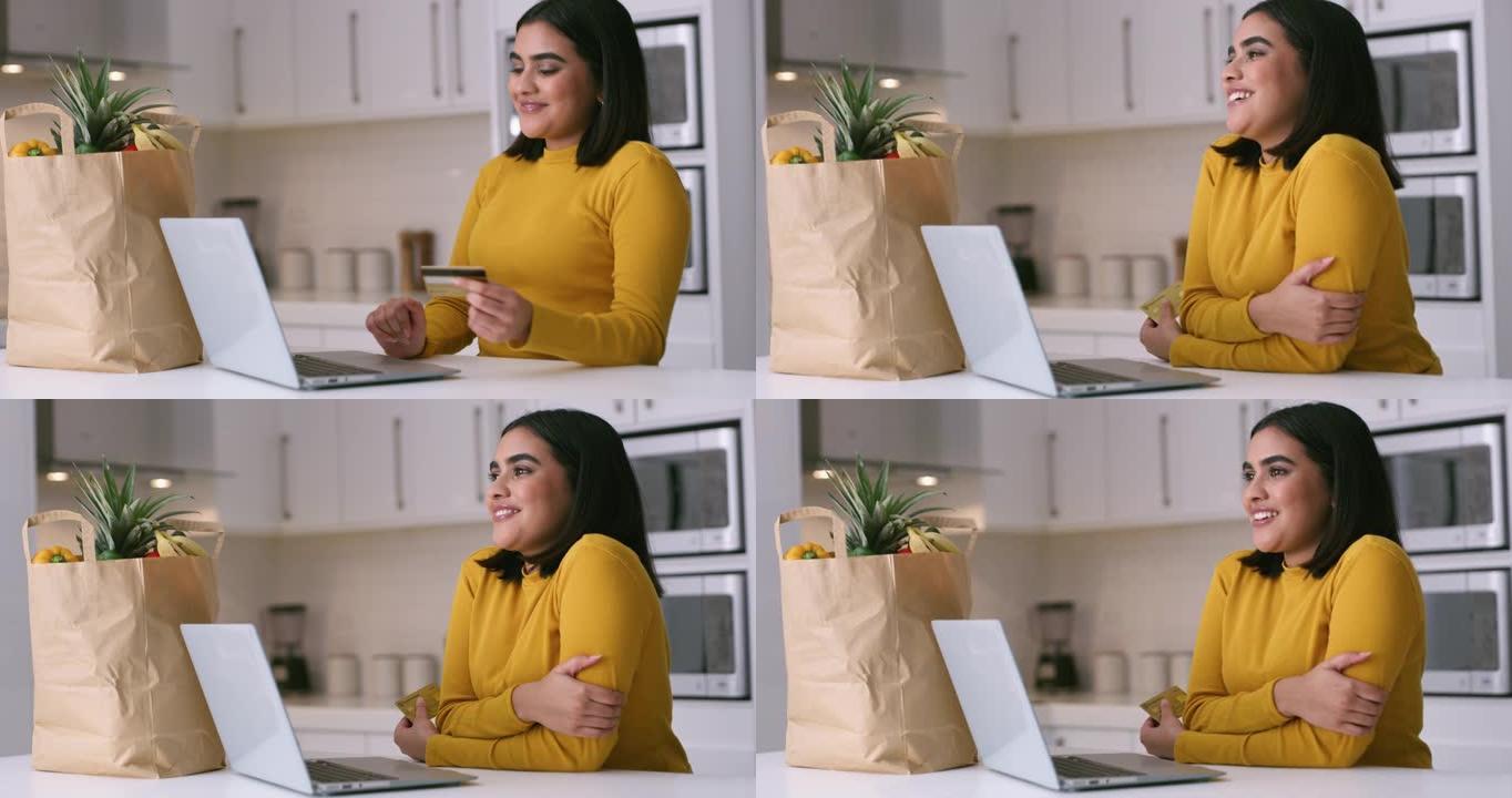 4k视频片段，一名年轻女子在家里的厨房里使用笔记本电脑和信用卡