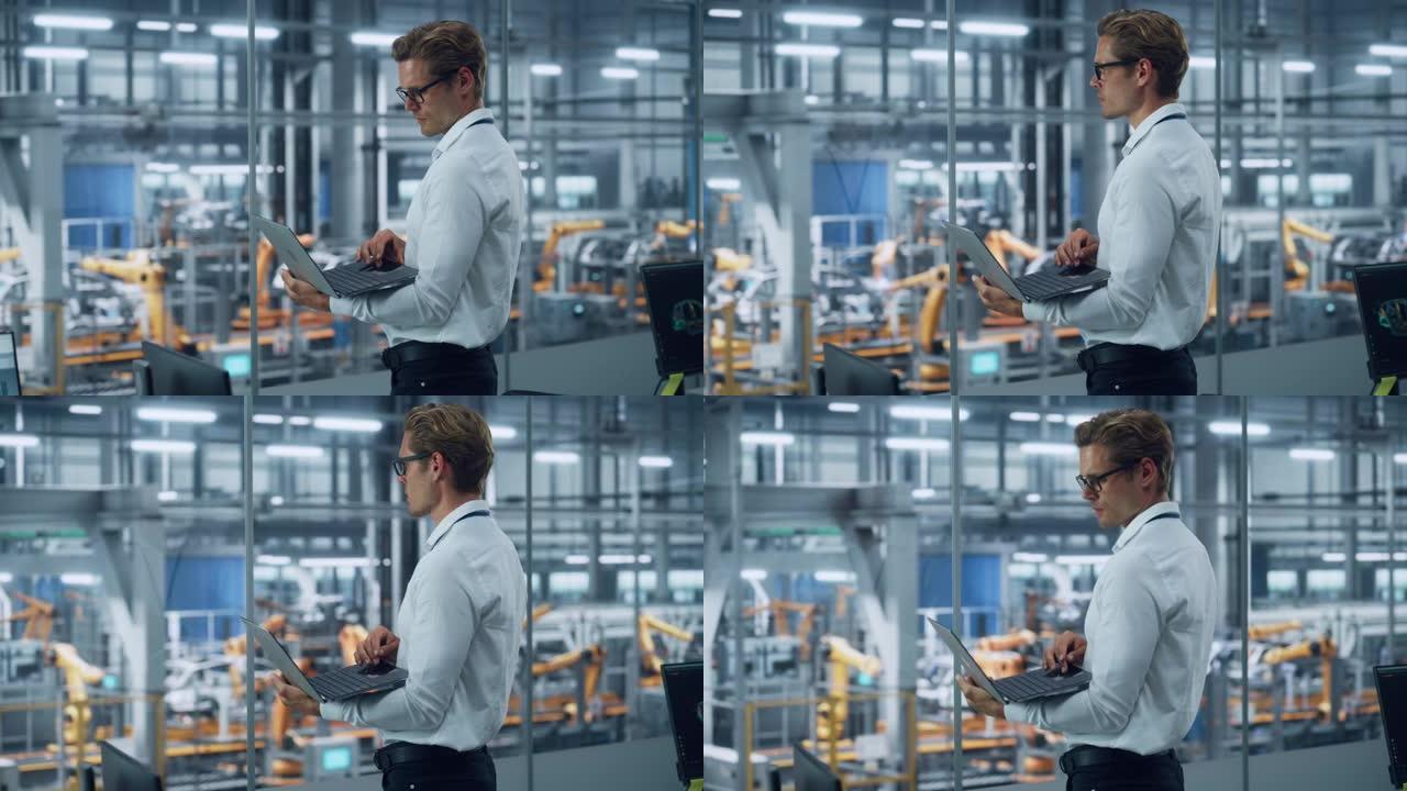 穿着眼镜和白衬衫的英俊工程师使用笔记本电脑，在汽车装配厂的办公室里望去。在技术设施中从事车辆设计的工