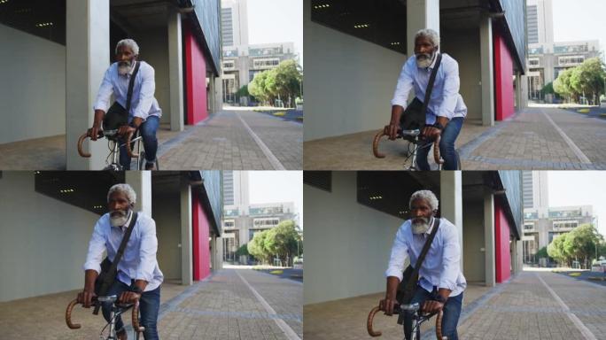 非裔美国高级男子在公司公园骑自行车