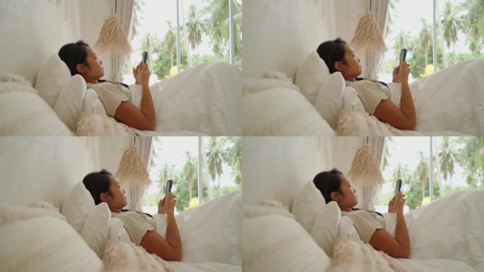 女子日裔在手机上网时躺在床上