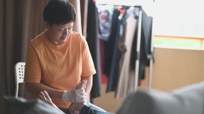 亚洲华裔女卫生工作者对她的病人高级妇女的腿进行物理治疗