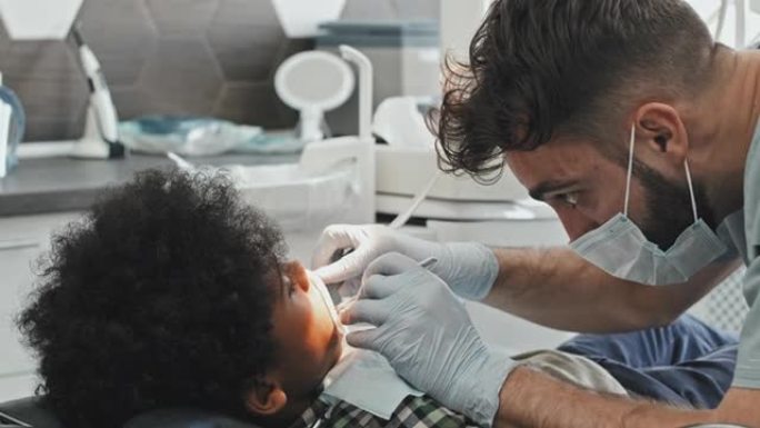 男性医生治疗男孩的牙齿