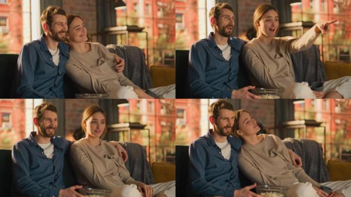 年轻夫妇在家里度过时光，坐在沙发上，男人在公寓里看激动人心的电视节目时拥抱女友的肖像。男人和女人流媒