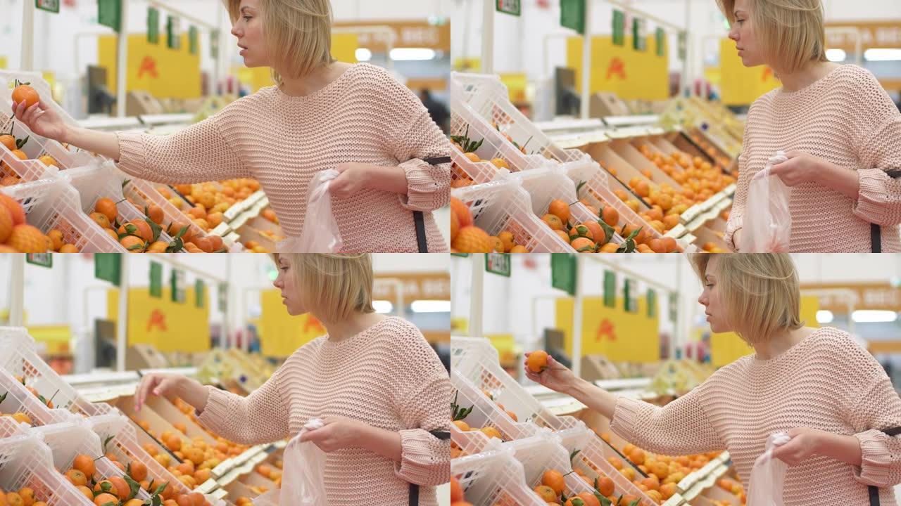 一个40多岁可爱的女性买家和采摘橙色水果架架室内超市。无忧无虑的女孩寻找牵手生物素食自然食品。绿色杂