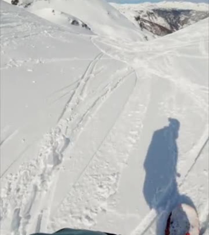 垂直视频POV拍摄的自由式滑雪者在下山时跳过岩石