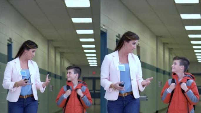 小学生与老师在学校走廊散步