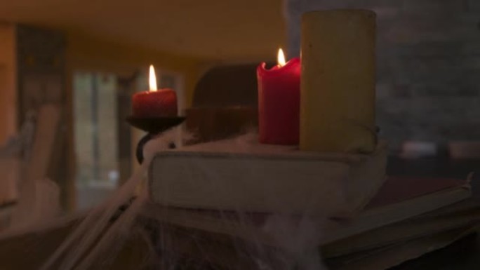 关闭红色燃烧的蜡烛和覆盖在蜘蛛网上的旧书，以庆祝万圣节的气氛